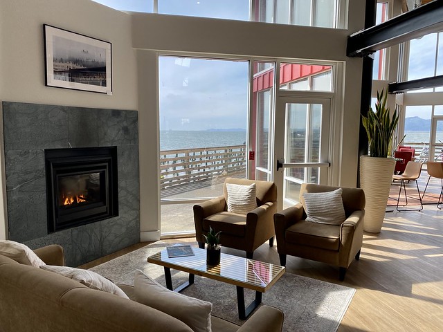 Cannery Pier Hotel & Spa lobby with gas fireplace. Door opens to outside wood pier over the Columbia River in Astoria, Oregon 