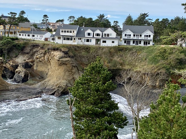 Three white buildings are home to the 19 room Inn at Arch Rock in Depoe Bay, Oregon. The boutique hotel sits above the Pacific Ocean in Oregon.