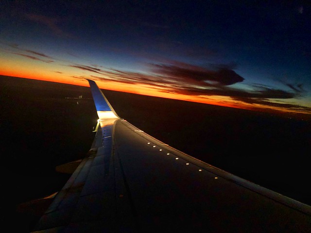 United Airlines wing tip lights up with the sun setting in Miami, Florida. 